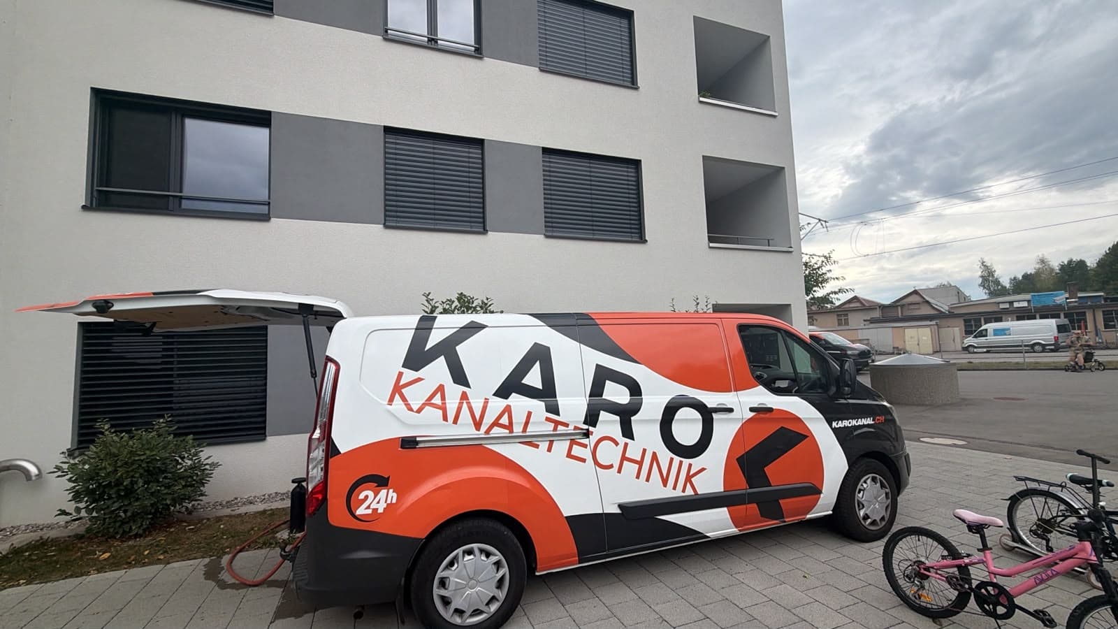Karo-Einsatzfahrzeug vor einem Mehrfamilienhaus beim Einsatz zur Reinigung des Fallstrangs