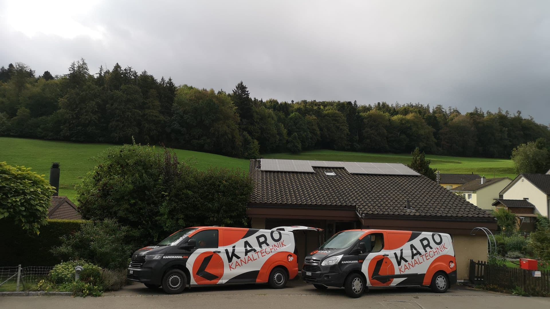 Zwei Karo-Einsatzfahrzeuge vor einem Einfamilienhaus bei Arbeiten am Hausanschluss